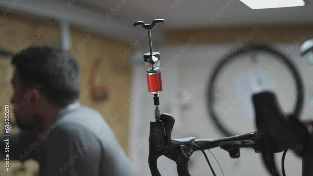 Bicycle mechanic holding syringe with brake fluid during brake bleeding