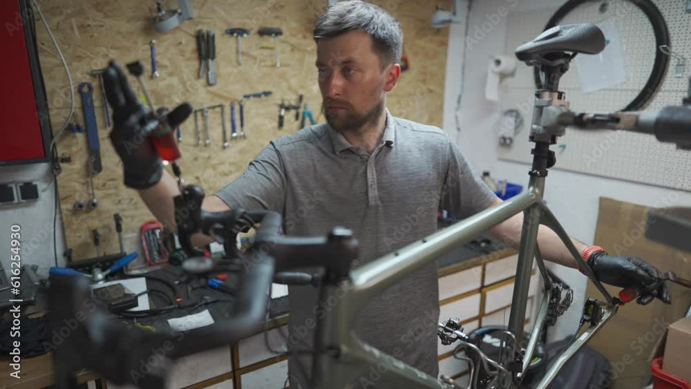 Bicycle mechanic holding syringe with brake fluid during brake bleeding