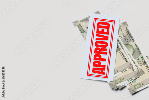 Bank loan approval concept: Indian currency and red stamp on white background with copy space.