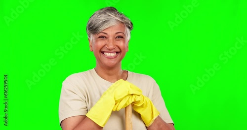 Face, senior woman and cleaner, green screen and happy housekeeper with broom and gloves on studio background. Cleaning service, female maid and house work with mockup space, smile and hygiene