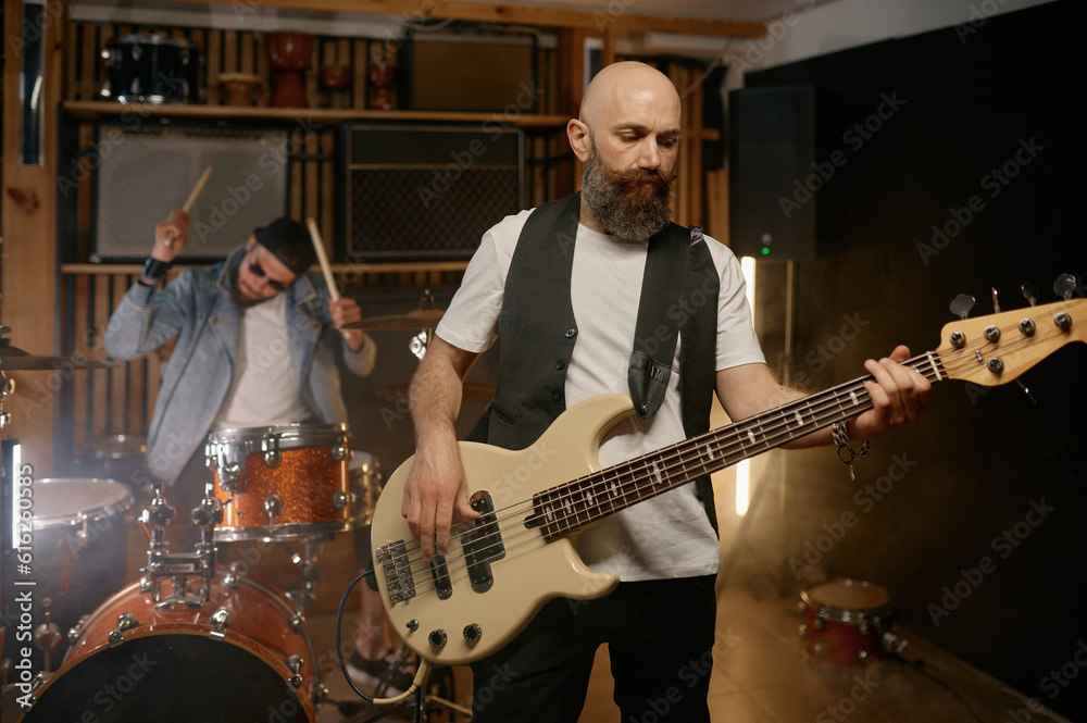 Fototapeta premium Rock rehearsal or live performance with focus on guitarist playing guitar