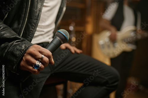 Closeup view of rock singer hand holding dynamic microphone