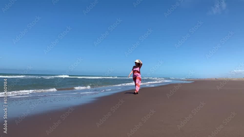 Mature woman relaxing during a walk at the beach. Summer concept, video 4k Mature woman relaxing during a walk at the beach. Summer concept, video 4k