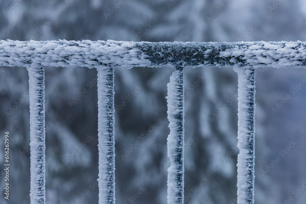 Metal railings of viewing tower covered with a lot of snow and ice faced to one side by strong wind Metal railings of viewing tower covered with a lot of snow and ice faced to one side by strong wind