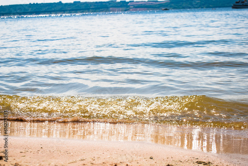 Sparkling silver waves in the sand. Summer beach background with a space for text.