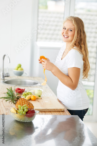 Woman portrait, eating orange and fruit for plus size health and nutrition for weight loss diet and healthy at home. Kitchen, fruits and food in a house with breakfast and nutritionist in the morning