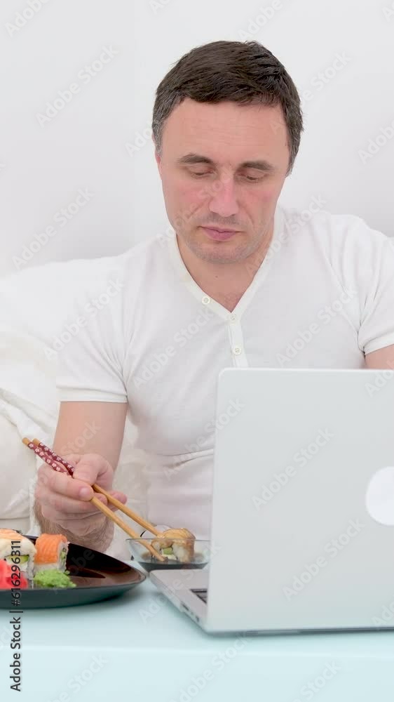 man white t-shirt eating sushi bed soy sauce putting wasabi top work online freelancer white blanket pillows relaxation food delivery healthy food leisure man white t-shirt eating sushi bed soy sauce putting wasabi top work online freelancer white blanket pillows relaxation food delivery healthy food leisure