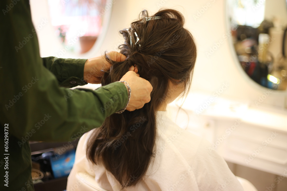 美容室でヘアセットをする女性