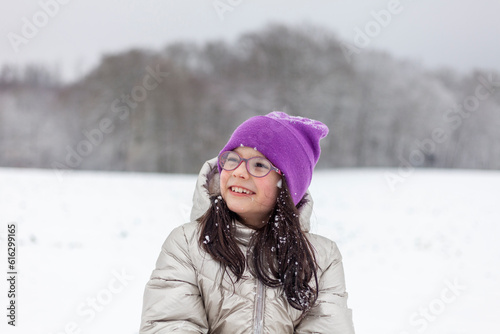 portrait of a beautiful girl in a purple hat on a background of winter landscape