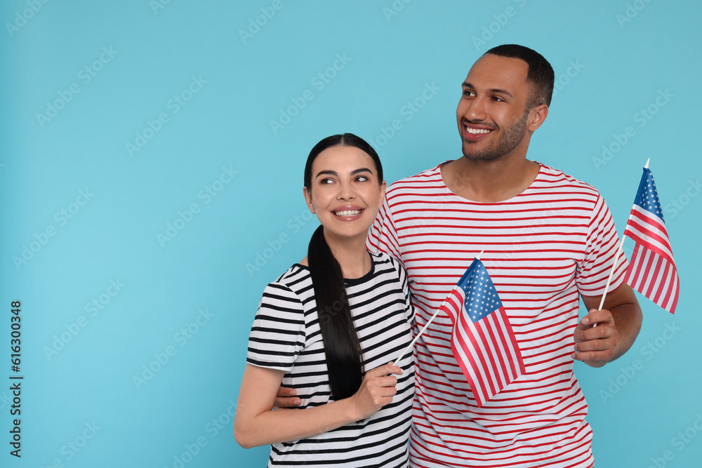 Obraz premium 4th of July - Independence Day of USA. Happy couple with American flags on light blue background, space for text