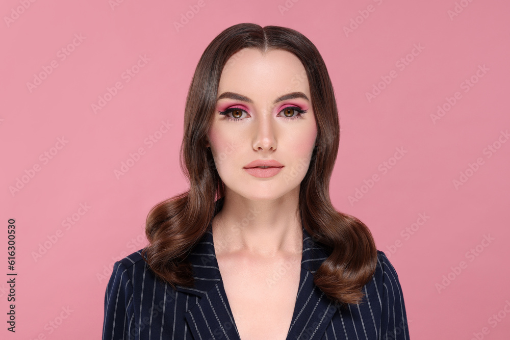 Portrait of beautiful young woman with makeup and gorgeous hair styling on pink background Portrait of beautiful young woman with makeup and gorgeous hair styling on pink background
