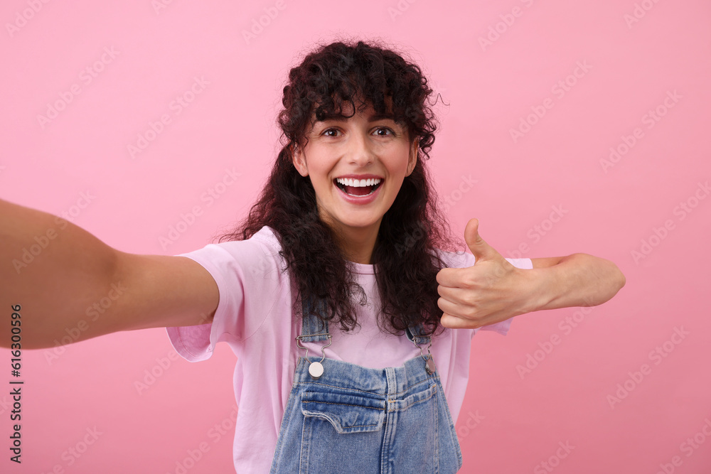 Beautiful woman taking selfie on pink background Beautiful woman taking selfie on pink background