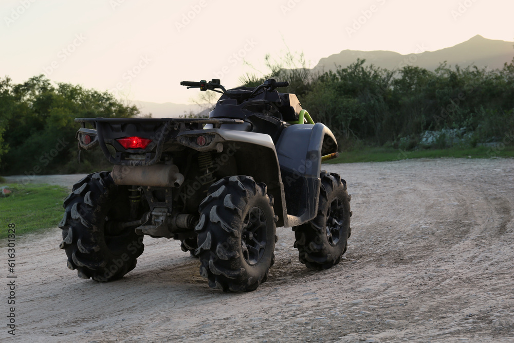Modern fast quad bike on pathway outdoors Modern fast quad bike on pathway outdoors