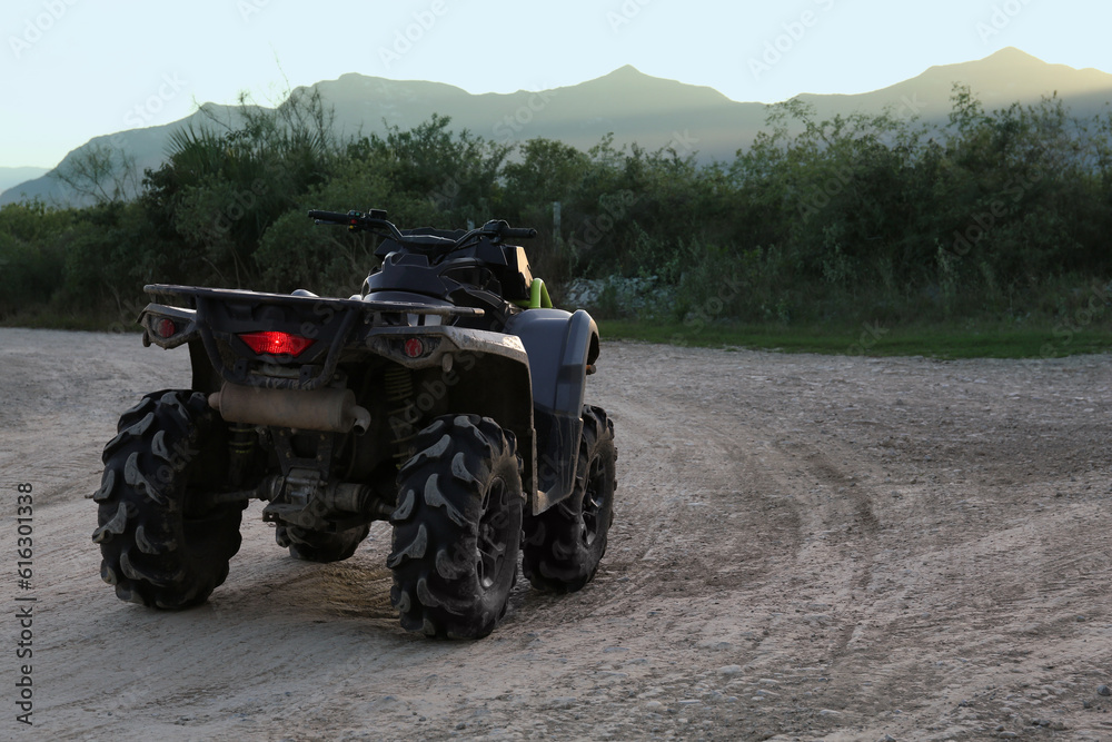Modern fast quad bike on pathway outdoors Modern fast quad bike on pathway outdoors