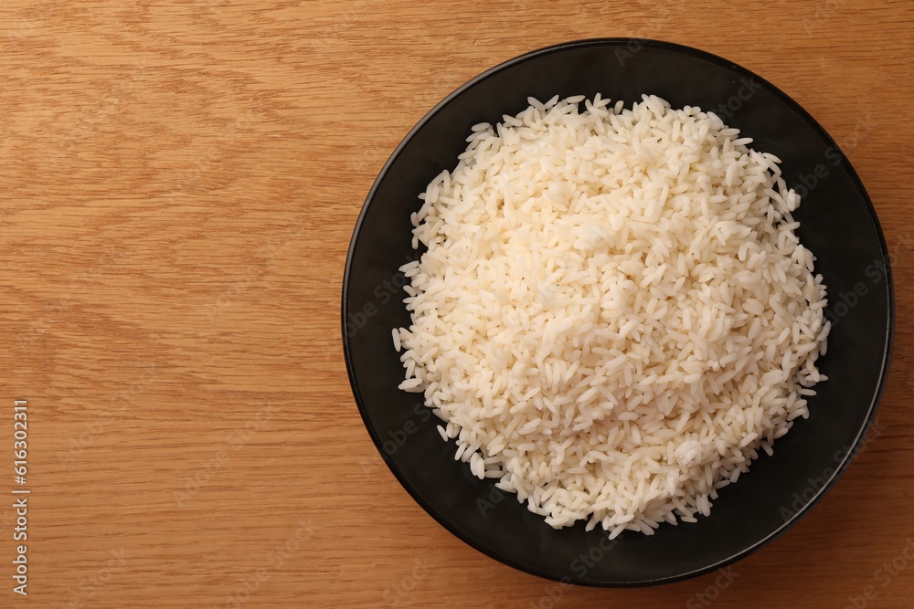 Plate with delicious rice on wooden table, top view. Space for text Plate with delicious rice on wooden table, top view. Space for text