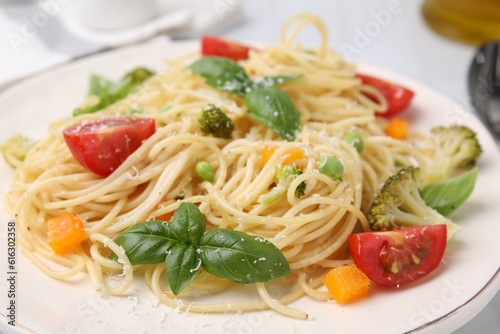 Delicious pasta primavera with tomatoes, basil and broccoli on plate, closeup