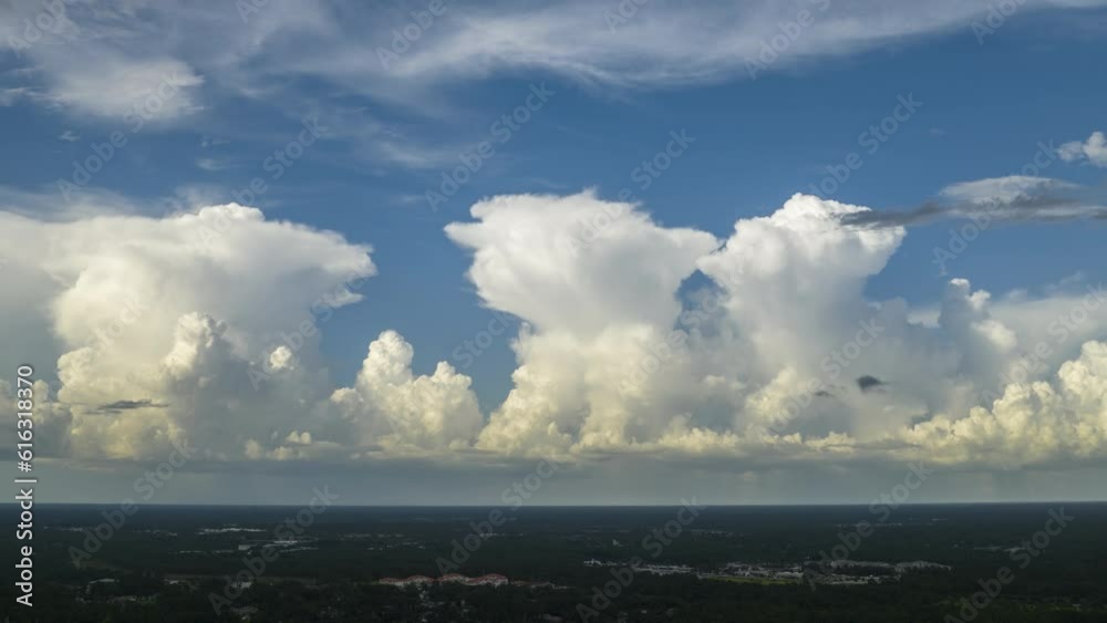 Tropical storm approaching over southern Florida landscape. Timelapse of white cumulonimbus clouds forming before thunderstorm on summer blue sky. Moving and changing cloudy weather