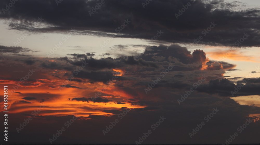 Fototapeta premium Sunset sky with clouds and sunbeams. Abstract background.