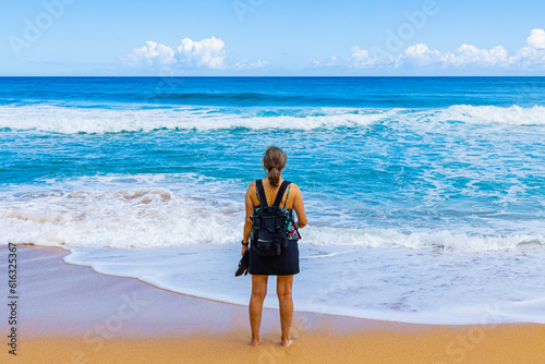 Female Tourist on The Sandy Shore of Kauapea Beach, Kauai, Hawaii, USA photo