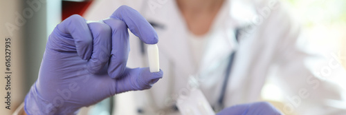 Fotografia Doctor proctologist holding in his hands antiinflammatory suppository for hemorr