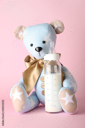 Teddy bear with bottle of m...