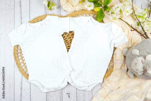 Baby two twins romper bodysuit onesie gender neutral mockup. Modern farmhouse theme SVG craft product mockup on a white wood background.