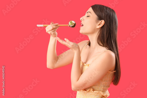Young woman eating sushi ro...
