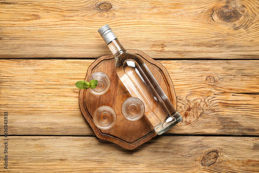 Bottle and glasses of vodka on wooden background - obrazy, fototapety, plakaty 