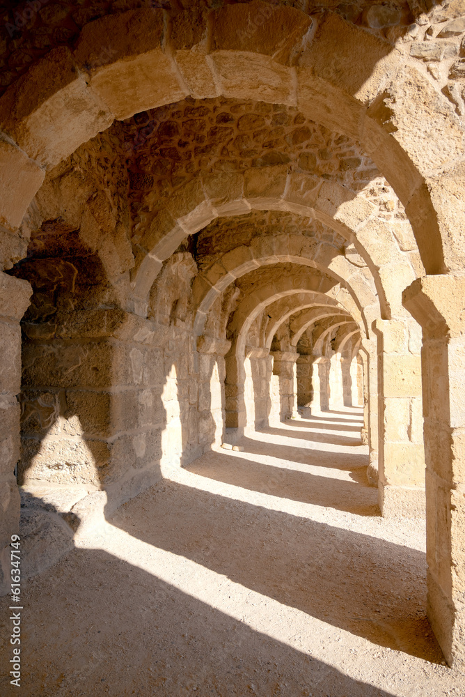Fototapeta premium Illuminated hallway under the arcs in the ancient Roman amphitheater