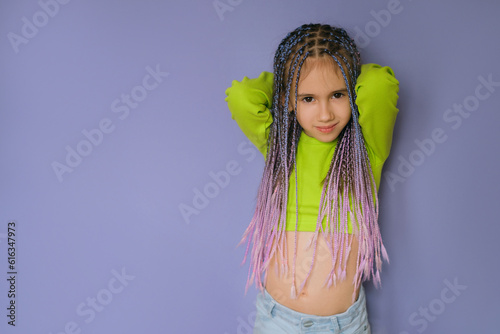 Stylish modern girl with a braided hairstyle with lots of braids of colored strands of artificial hair