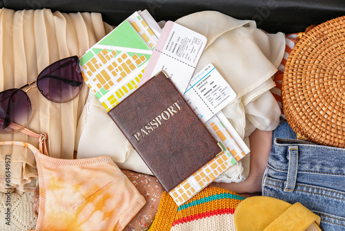 Texture of suitcase with clothes, beach accessories, passport and tickets as background. Travel concept