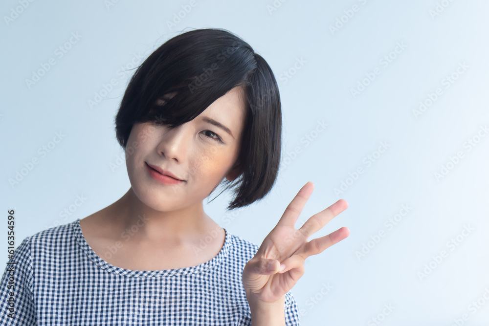 Happy smiling asian woman with short hair pointing up three fingers, 3 points gesture Happy smiling asian woman with short hair pointing up three fingers, 3 points gesture