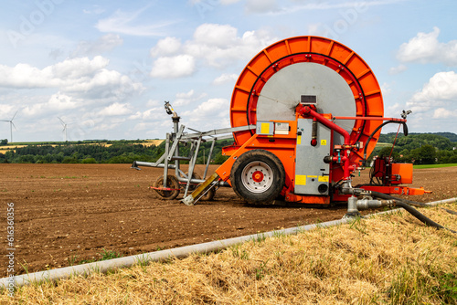 Obraz na płótnie Dérouleur de tuyau pour l'irrigation agricole au bord d'un champ w salonie