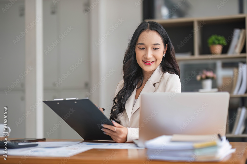 A beautiful and professional Asian businesswoman using her laptop to manage his tasks, working at the office. A beautiful and professional Asian businesswoman using her laptop to manage his tasks, working at the office.