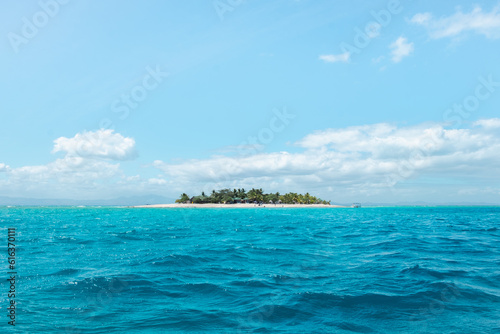 A small inhabited island surrounded by turquoise water on a sunny day, the perfect luxury holiday destination, Fiji photo