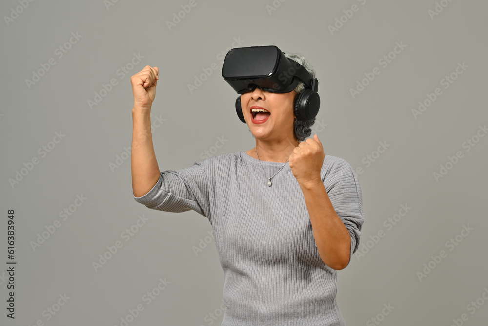 Excited senior woman VR headset enjoying virtual reality experience. Modern technologies, innovations and gadgets Excited senior woman VR headset enjoying virtual reality experience. Modern technologies, innovations and gadgets