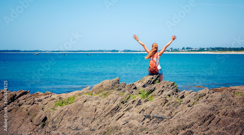 woman with outstreched arms enjoying view of the sea- vacation, freedom,travel destination concept