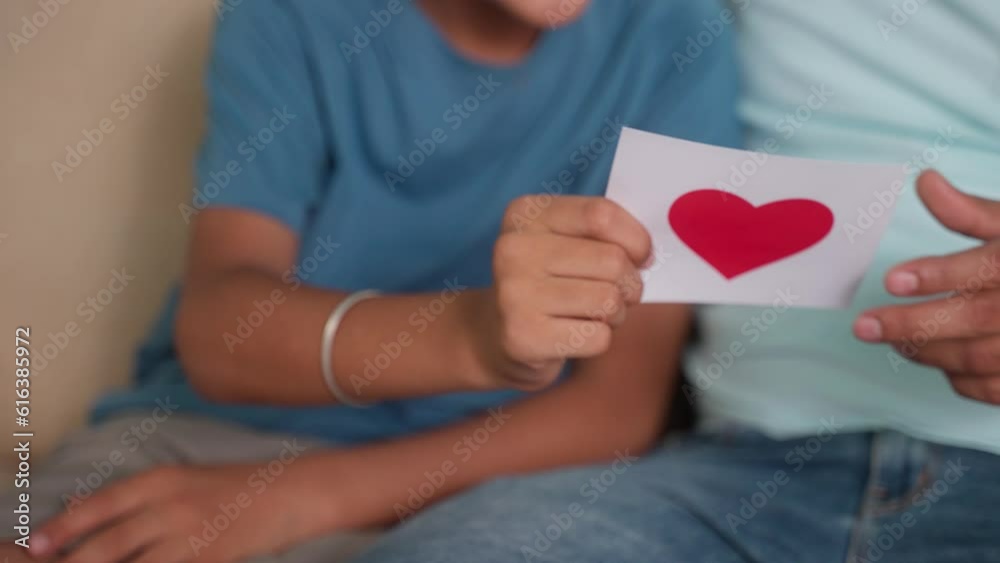 Close up shot of son hands giving greeting card to father at home - concept of relationship, family bonding and father's day present. Close up shot of son hands giving greeting card to father at home - concept of relationship, family bonding and father's day present.