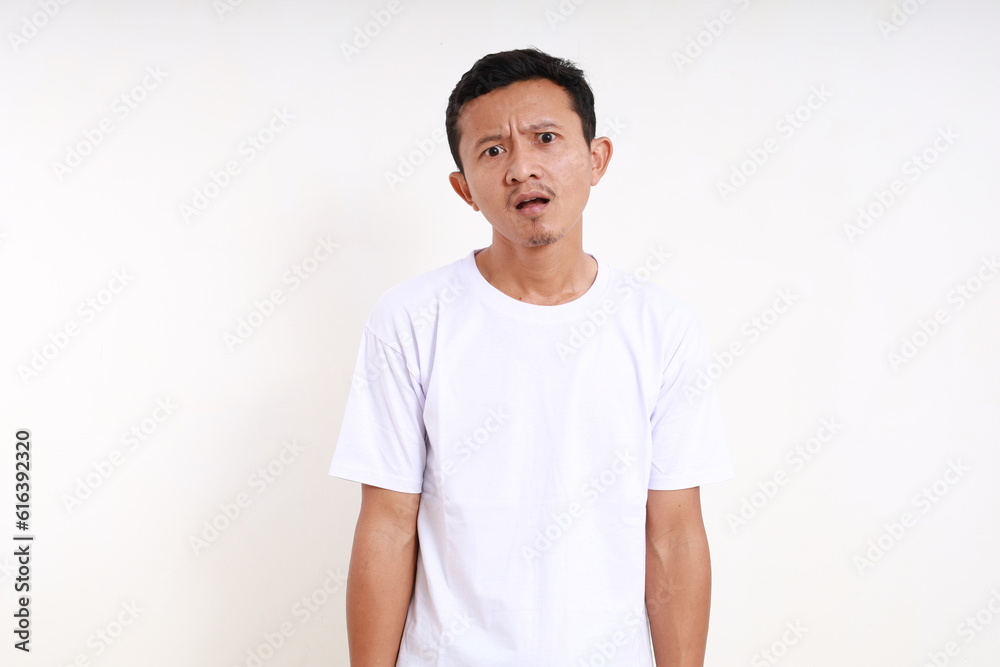 Asian funny man standing with confused face expression. Isolated on white background Asian funny man standing with confused face expression. Isolated on white background