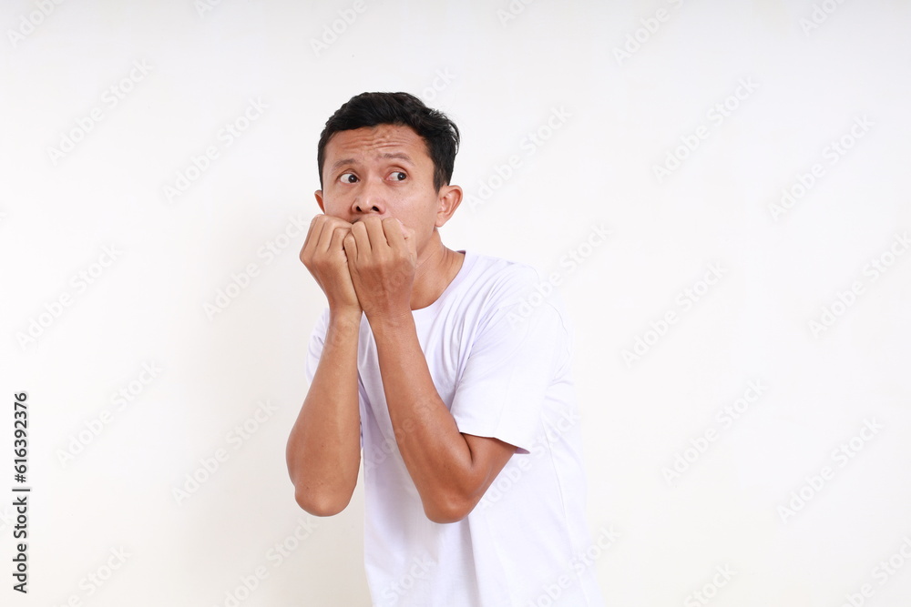 Asian funny man standing with afraid scared face expression. Isolated on white with copyspace Asian funny man standing with afraid scared face expression. Isolated on white with copyspace