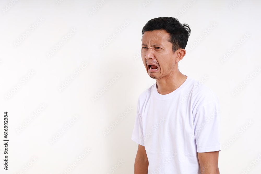 Disappointed asian funny man standing while looking beside. Isolated on white background Disappointed asian funny man standing while looking beside. Isolated on white background