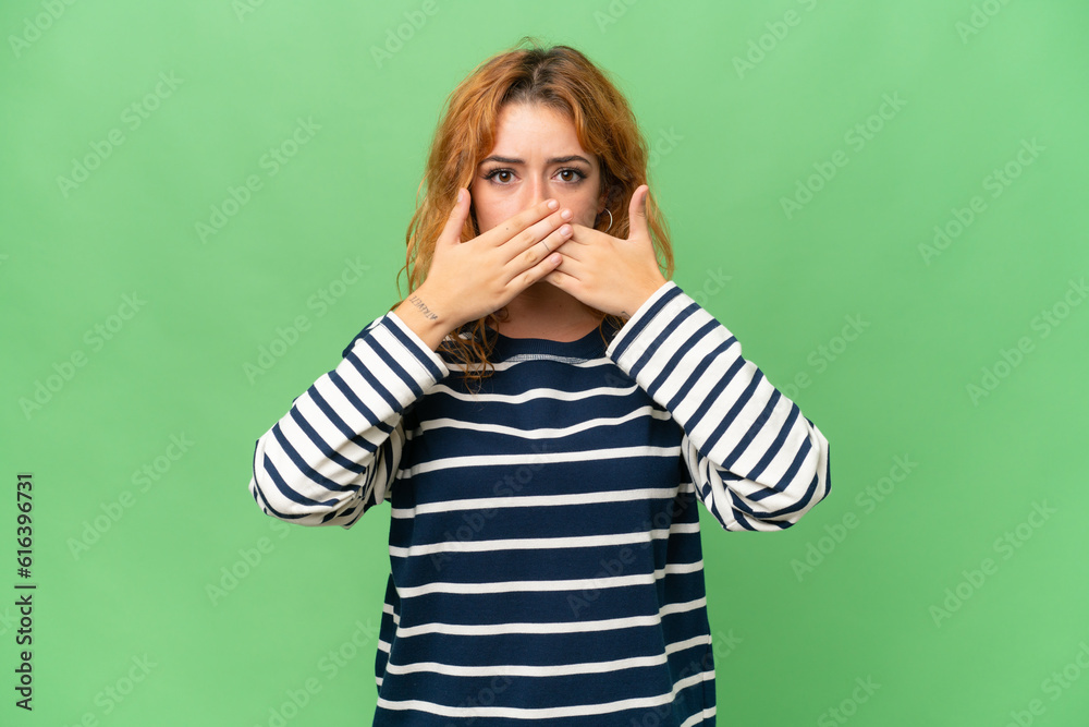 Young caucasian woman isolated on green screen chroma key background covering mouth with hands Young caucasian woman isolated on green screen chroma key background covering mouth with hands