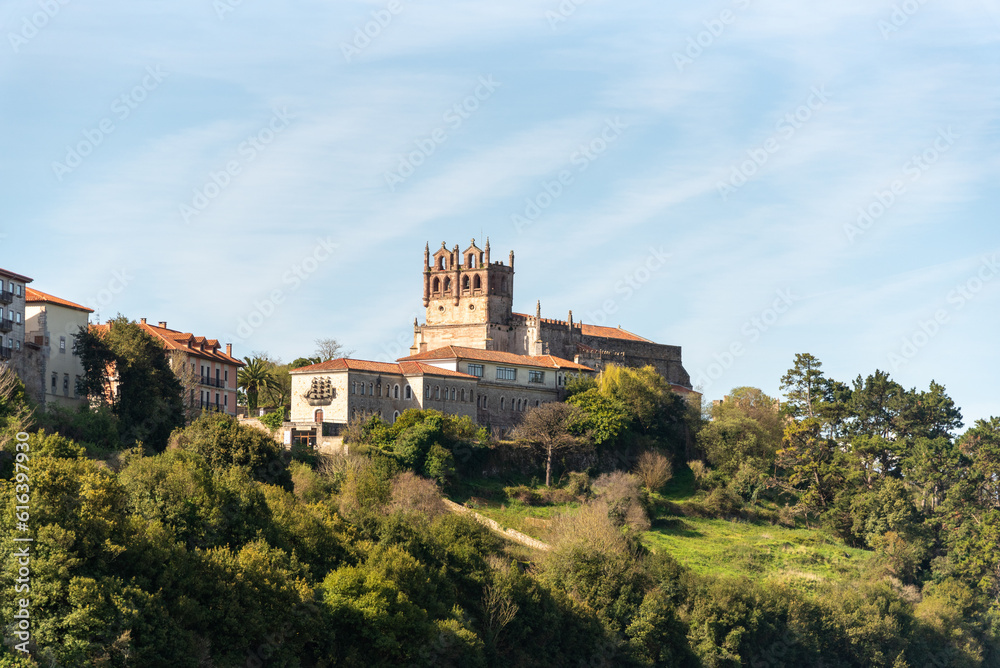 Panoramic view of the medieval castle of San Vicente de la barquera. On the top of a hill surrounded by vegetation and next to the sea during a sunny summer day in cantabria.