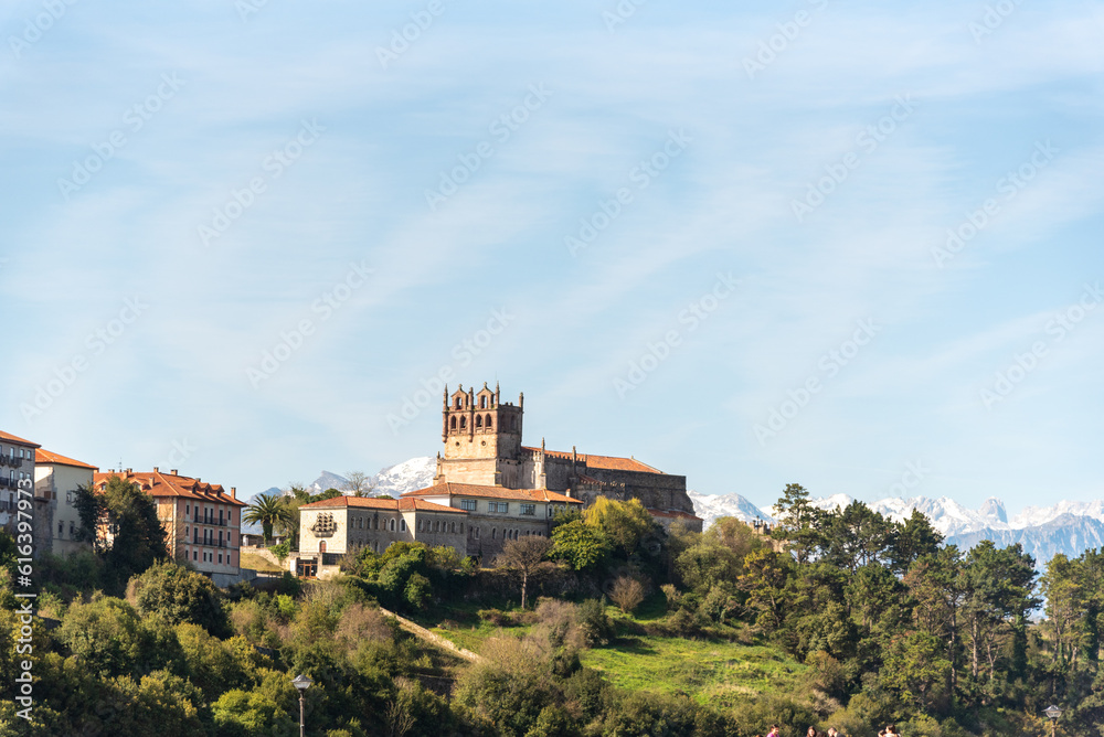 Panoramic view of the medieval castle of the tourist village of San Vicente de la Barquera in Cantabria surrounded by an impressive natural landscape with the snow-capped Picos de Europa 