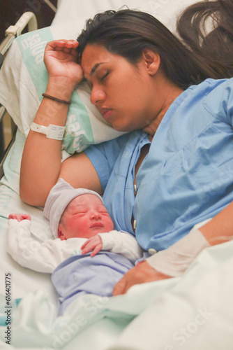 Woman with her newborn baby sleeping in the hospital