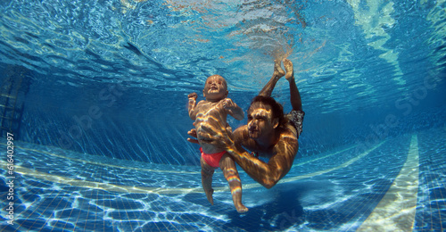 Funny photo of happy active family young father with active baby diving in swimming pool with fun jump deep down underwater.
