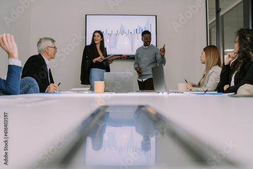 A low angle view photo of multiracial coworkers explaining project details to their colleagues