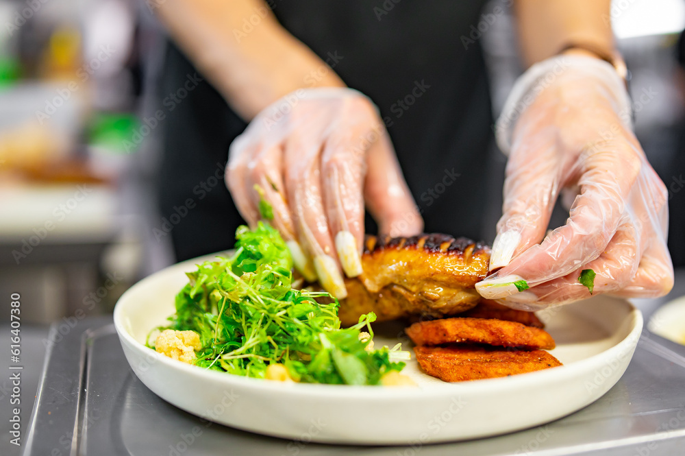 chef hand cooking Roasted Duck breast fillets with vegetable salad and batat in plate on restaurant kitchen