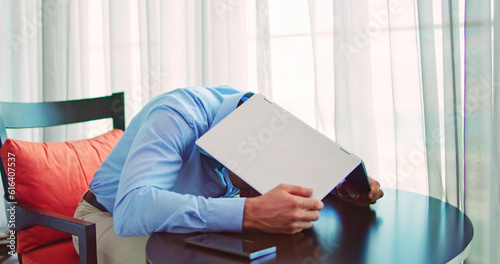 Obraz na plátně Embarrassed Businessman Hiding Under Laptop