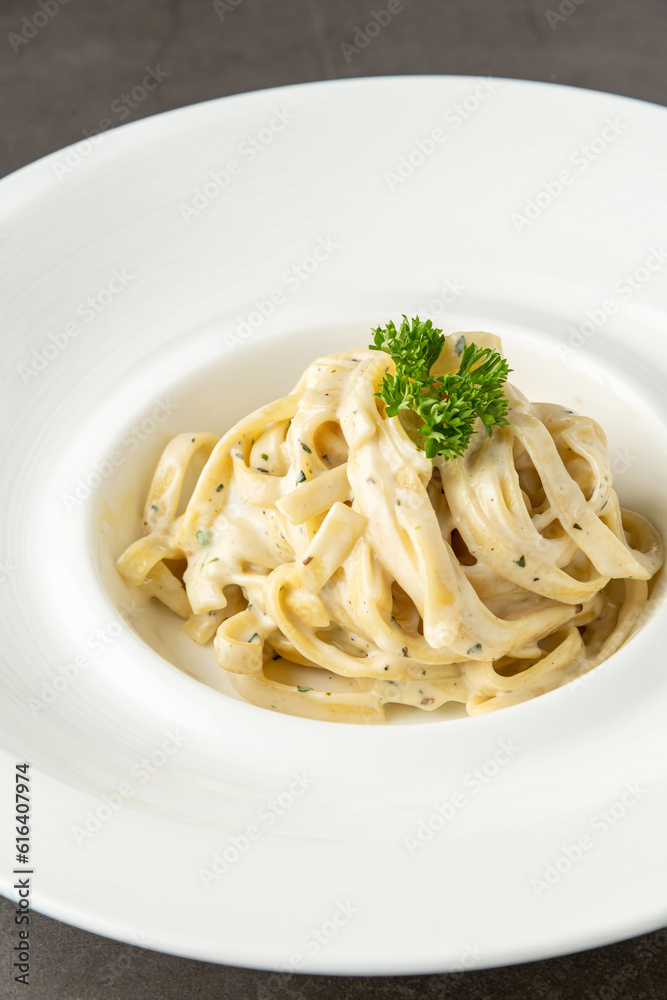 Freshly made fettucini alfredo on a white porcelain plate